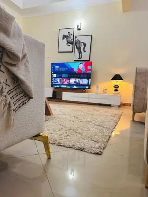 a living room with a large flat screen tv at In arusha nests in Arusha