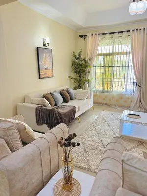 a living room with two couches and a table at In arusha nests in Arusha