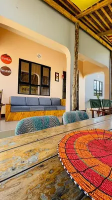 a table with chairs and a couch in a room at Safari Roots Hostel in Arusha