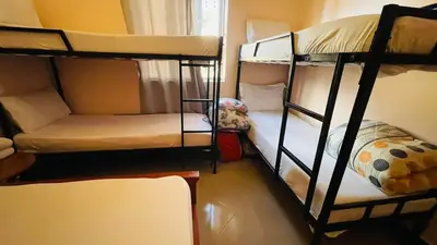 a room with three bunk beds and a couch at Safari Roots Hostel in Arusha