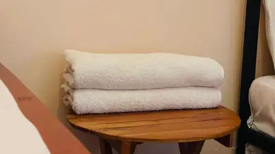a stack of white towels sitting on a wooden table at Safari Roots Hostel in Arusha