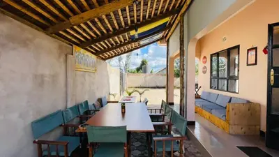 a restaurant with a table and chairs and a couch at Safari Roots Hostel in Arusha