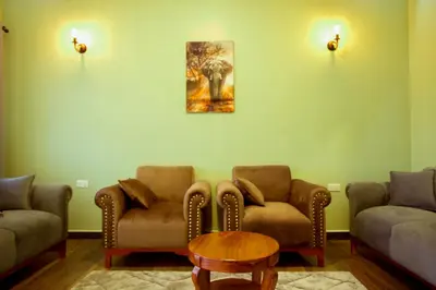a waiting room with two chairs and a table at Sarnah Apartments in Arusha