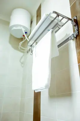 a towel rack in a bathroom with white towels at Sarnah Apartments in Arusha