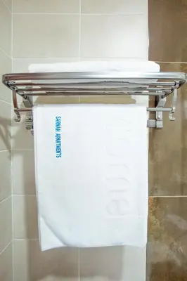 a towel rack with white towels on it in a bathroom at Sarnah Apartments in Arusha
