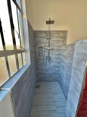 a bathroom with a shower with blue tiles at Nalala in Arusha