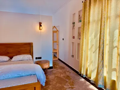 a bedroom with a bed and a table and a window at Nalala in Arusha