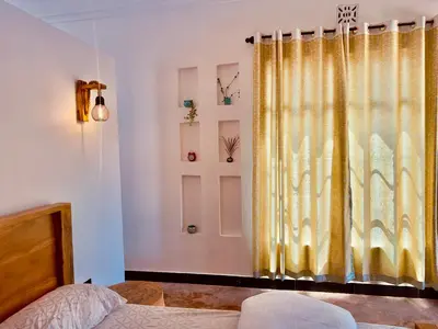 a bedroom with a yellow curtain and a bed at Nalala in Arusha