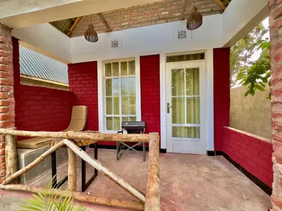 a red brick house with a patio with chairs at Nalala in Arusha