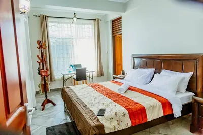 a bedroom with a bed and a desk and a window at Bellevie Homestay in Uru