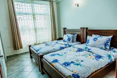 two twin beds in a room with a window at Bellevie Homestay in Uru