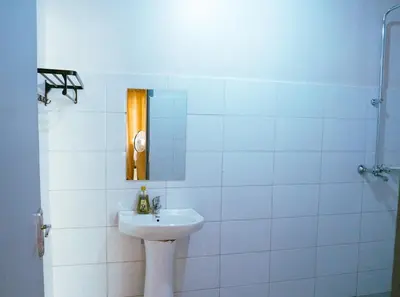 a white bathroom with a sink and a mirror at Garden Villa 5BR Home Near Road,Nature and City Life in Arusha