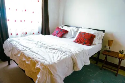 a bed with two pillows on it in a bedroom at Garden Villa 5BR Home Near Road,Nature and City Life in Arusha