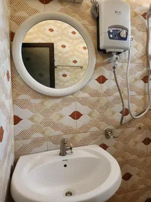 a bathroom with a sink and a mirror at Garden Inn Eco Stay in Msaranga