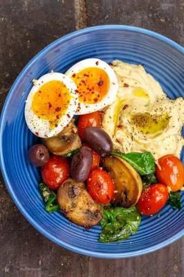 a blue plate of eggs and vegetables on a table at Garden Inn Eco Stay in Msaranga