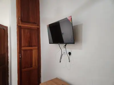 a flat screen tv hanging on a wall at Garden Inn Eco Stay in Msaranga