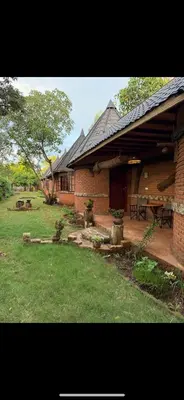 a brick house with a picnic table in a yard at The Fort Valley BnB , Karatu in Karatu
