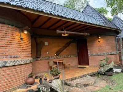 a brick house with a patio with a table and chairs at The Fort Valley BnB , Karatu in Karatu