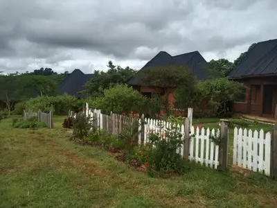 a white picket fence in front of a house at The Fort Valley BnB , Karatu in Karatu