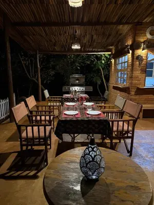 a dining room with tables and chairs and a stove at The Fort Valley BnB , Karatu in Karatu