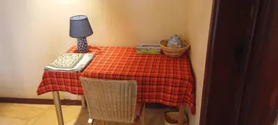 a table with a red plaid table cloth and a lamp at The Fort Valley BnB , Karatu in Karatu