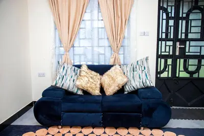 a blue couch with pillows in front of a window at Apollo Villa homestay in Arusha