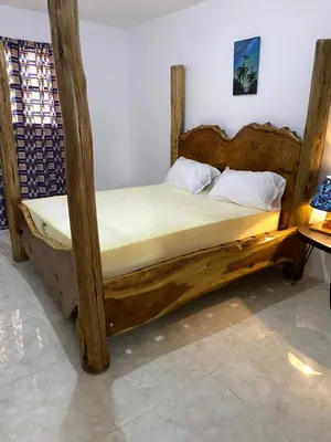 a bed with a wooden frame in a room at Mount Meru Baraka House