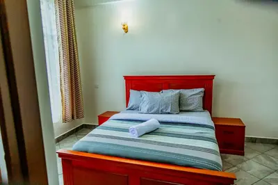 a bedroom with a bed with a red head board at Bellevie Homestays in Uru