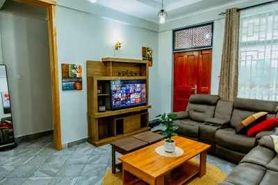a living room with a couch and a tv at Bellevie Homestays in Uru