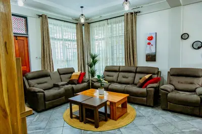 a living room with couches and a coffee table at Bellevie Homestays in Uru