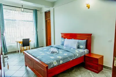 a bedroom with a bed and a table and a window at Bellevie Homestays in Uru
