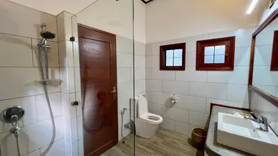 a bathroom with a shower and a toilet and a sink at Green Hills Lodge in Usa River