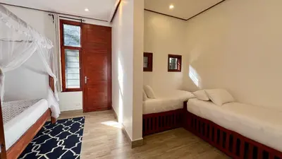a small room with two beds and a window at Green Hills Lodge in Usa River