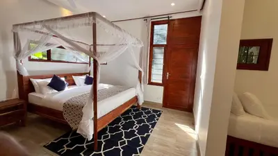 a bedroom with a canopy bed and a rug at Green Hills Lodge in Usa River