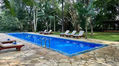 a swimming pool with lounge chairs next to a resort at Green Hills Lodge in Usa River