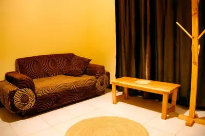 a living room with a couch and a table at Gift Homestay in Karatu