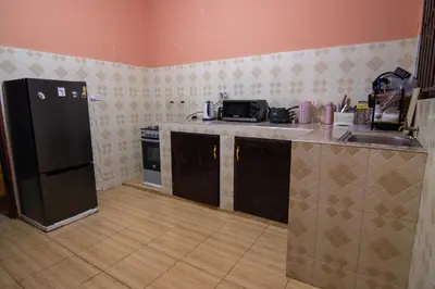 a kitchen with a black refrigerator and a sink at Simba homes in Arusha