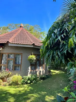 a small house with a tile roof on a yard at Nature's Haven Ilboru Hideaway in Arusha