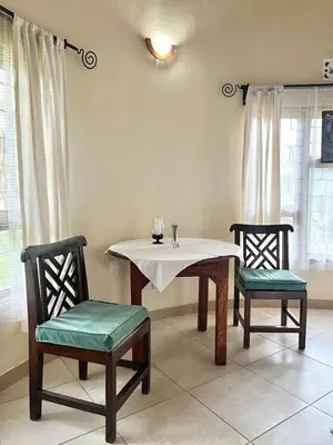 a dining room with a table and two chairs at Nature's Haven Ilboru Hideaway in Arusha