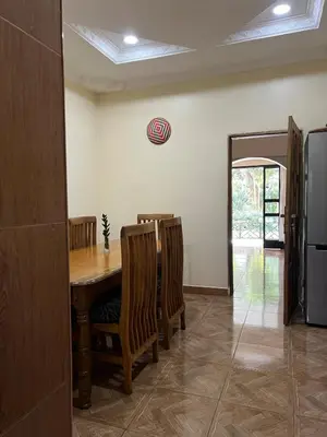 a dining room with a wooden table and chairs at Nature's Haven Ilboru Hideaway in Arusha