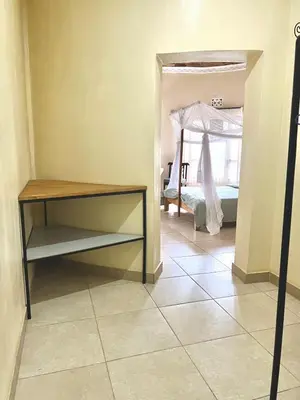 a bedroom with a bed and a table and a mirror at Nature's Haven Ilboru Hideaway in Arusha