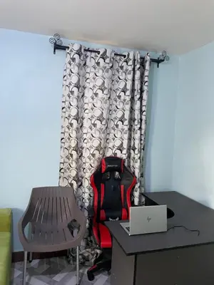 a room with a chair and a desk with a laptop at MSF BACHELOR PAd in Arusha