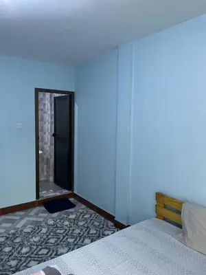 a blue room with a bed and a mirror at MSF BACHELOR PAd in Arusha
