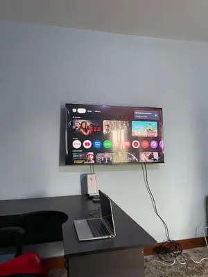 a computer monitor on a wall with a laptop on a desk at MSF BACHELOR PAd in Arusha