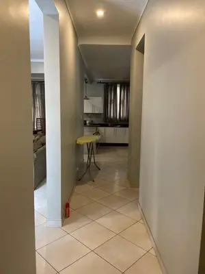 a hallway with a room with a table and a kitchen at Attorney Pad in Arusha