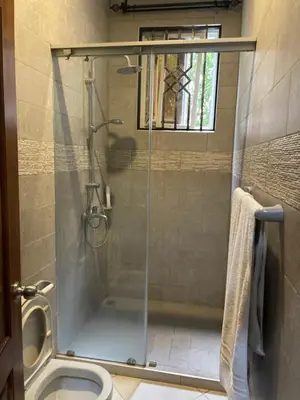 a shower with a glass door in a bathroom at Attorney Pad in Arusha