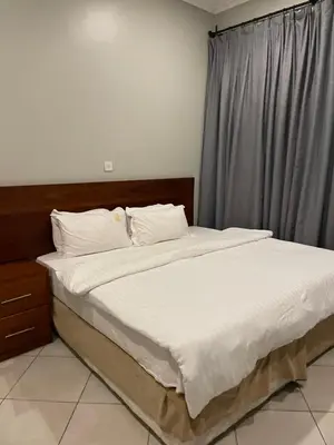 a bed with white sheets and pillows in a bedroom at Attorney Pad in Arusha