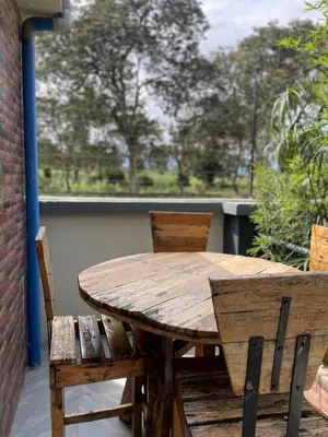 a wooden table and chairs on a balcony with a window at Luxurious 2bed in Arusha