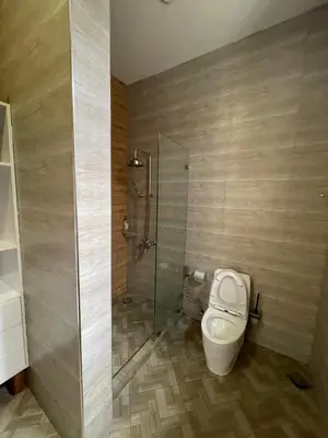 a bathroom with a toilet and a glass shower at Luxurious 2bed in Arusha