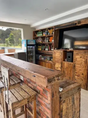 a wooden bar with a bench and a tv at Luxurious 2bed in Arusha